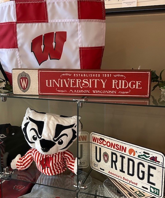 Shelf with University Ridge signs and a Bucky Badger headcover